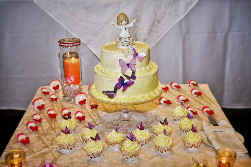 Infant's feet ascending from baptismal font water during baptising in Greece photographer