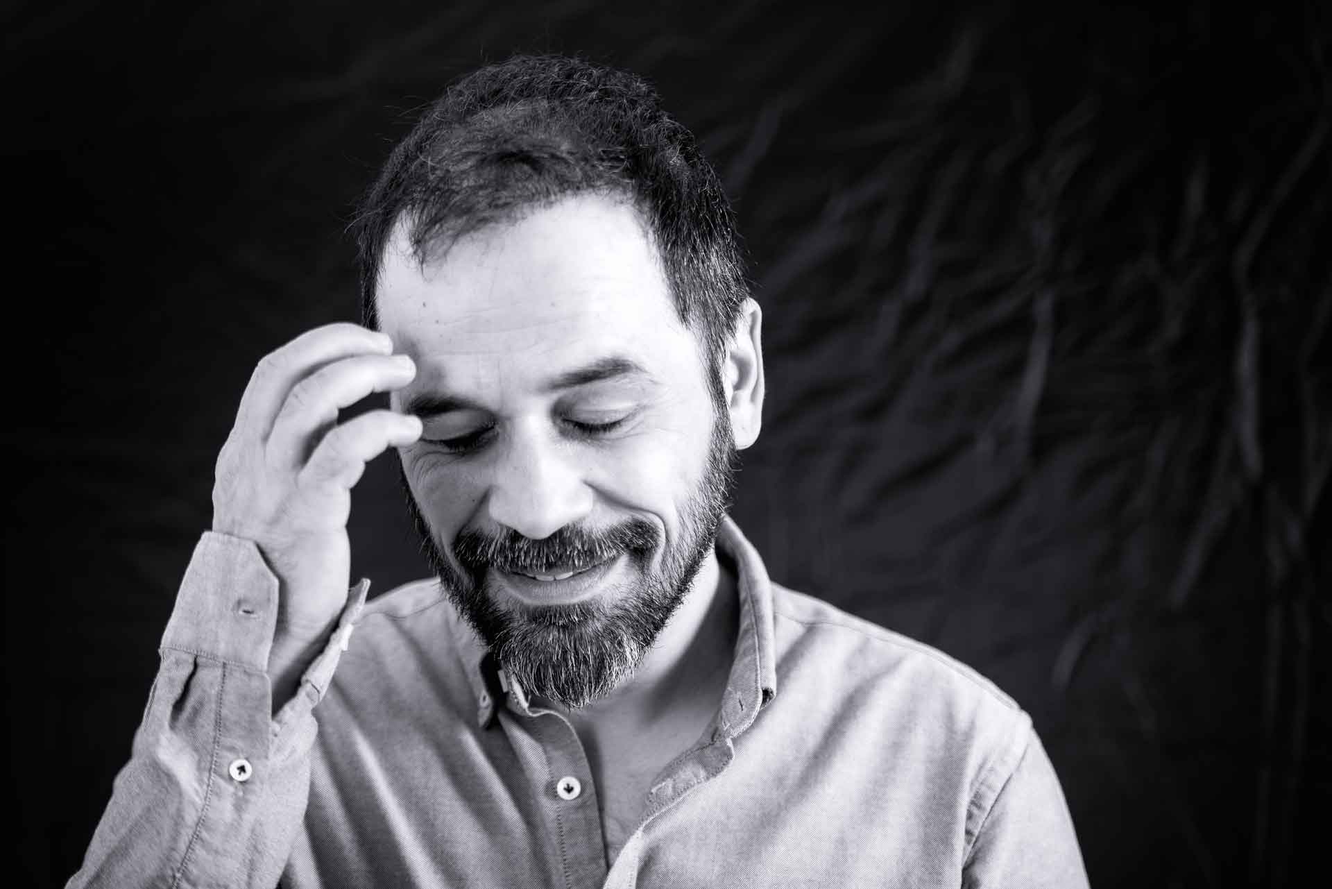 Portrait of photographer Mike Paschos shying away from camera